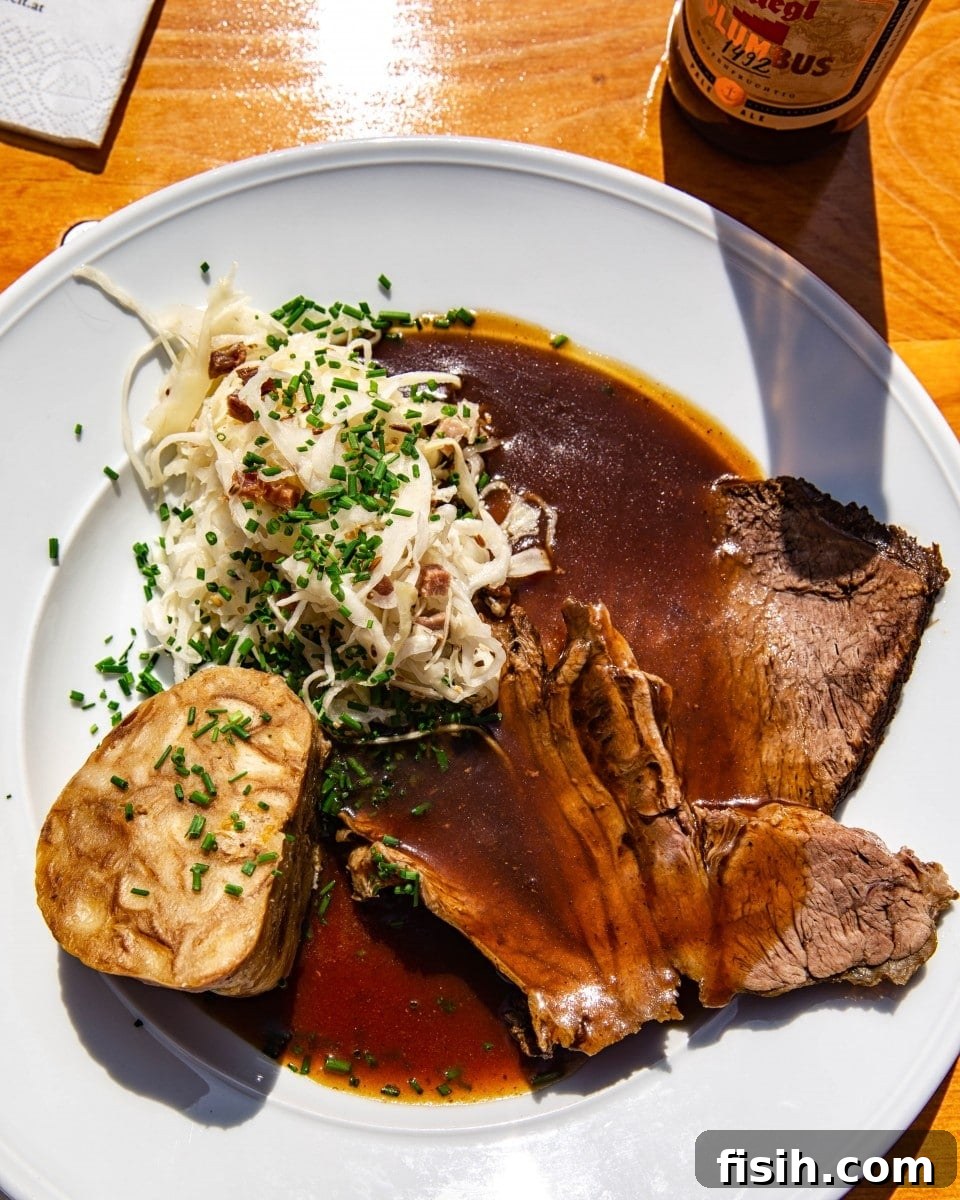 A hearty plate of traditional Austrian food: succulent meat, a soft dumpling, and tangy sauerkraut