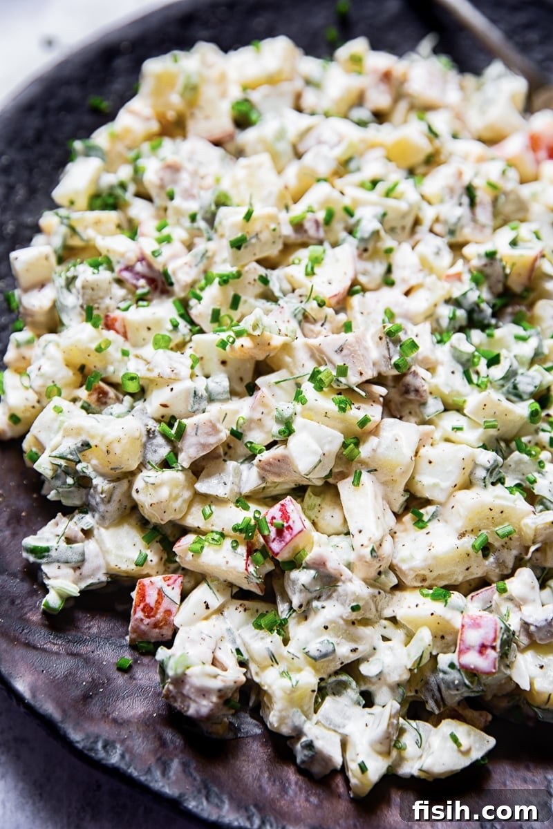 A vibrant and close-up view of Russian salad Olivier, showcasing its rich texture and colorful diced ingredients, ready to be served.