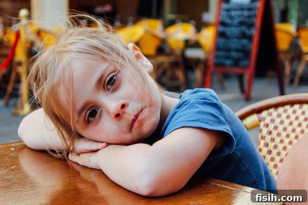 Child enjoying a croissant and hot chocolate, a typical travel treat