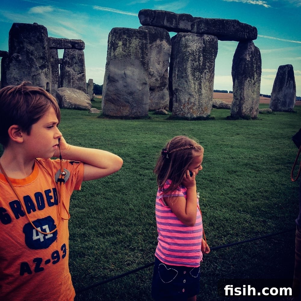 Children eagerly listening to an audio guide while visiting a historic castle