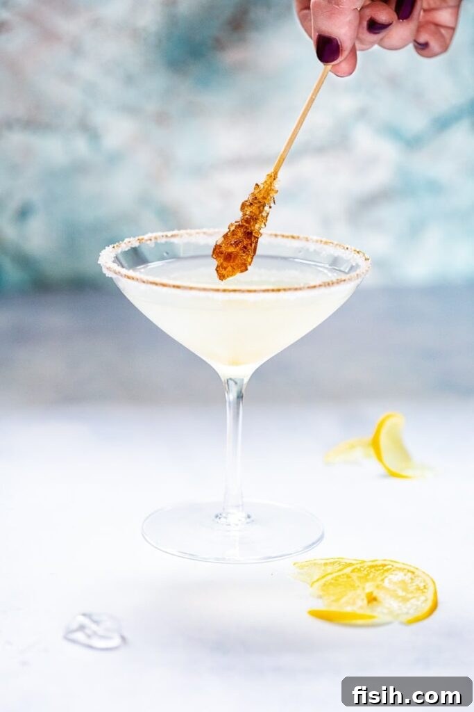 Side shot of sugar coated stir stick dipping into Lemon Drop Martini
