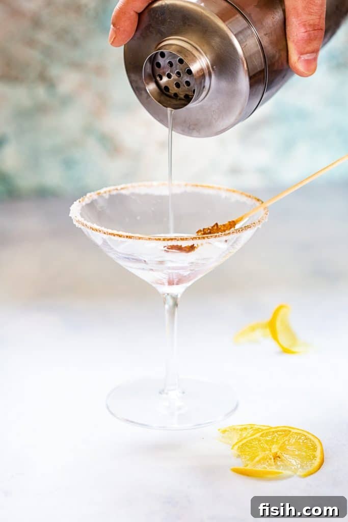 Close up of lemon drop martini pouring into martini glass