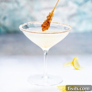 Side shot of sugar coated stir stick dipping into Lemon Drop Martini