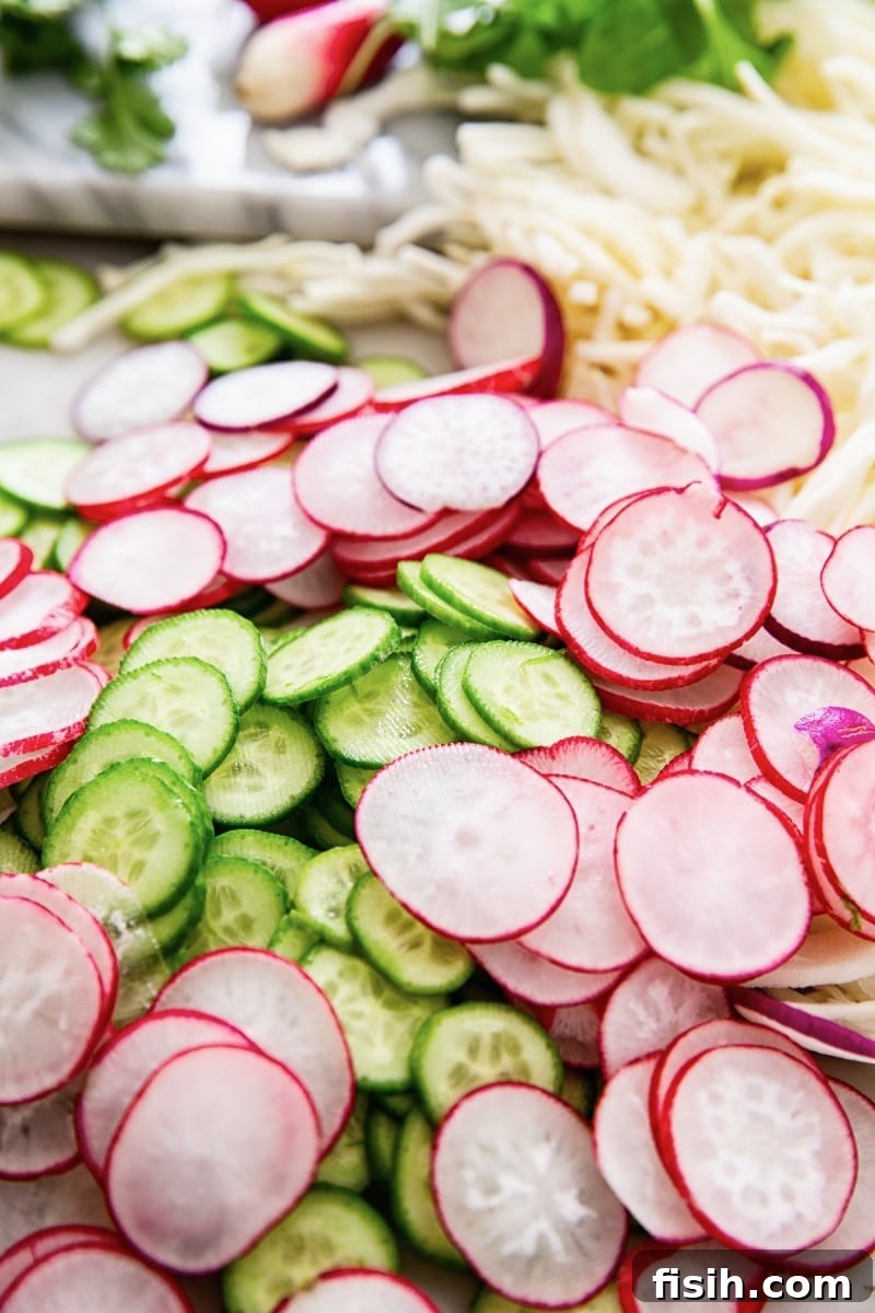 Creamy Keto Cabbage Slaw 6 Close-up of thinly sliced cucumbers and radishes, ready for the salad