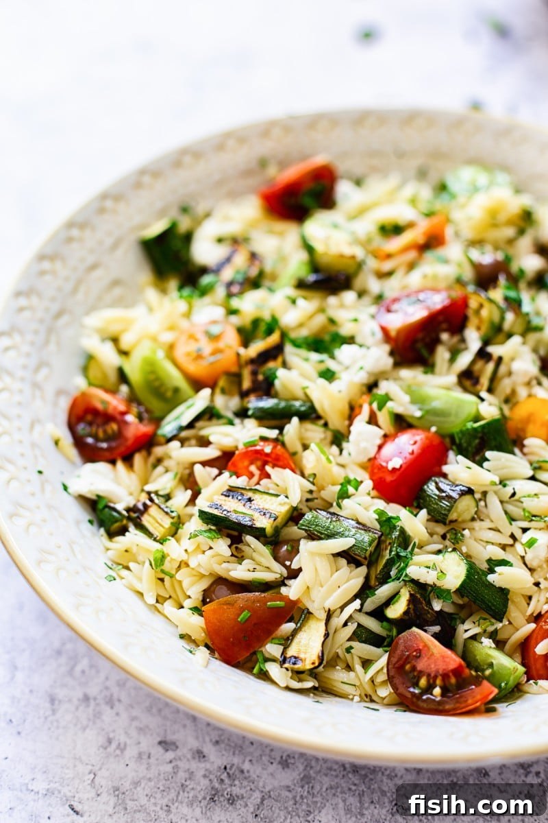 Mediterranean Orzo Salad with Grilled Zucchini 4 A serving of Greek Orzo Salad with grilled zucchini, tomatoes, feta, and olives.