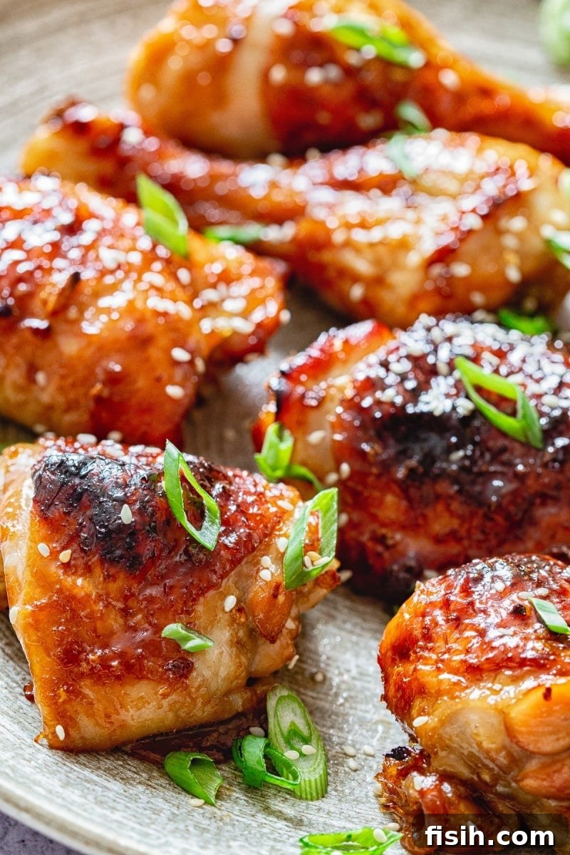 Close-up shot of individual sticky Asian chicken pieces, showcasing the glossy glaze and tender meat.