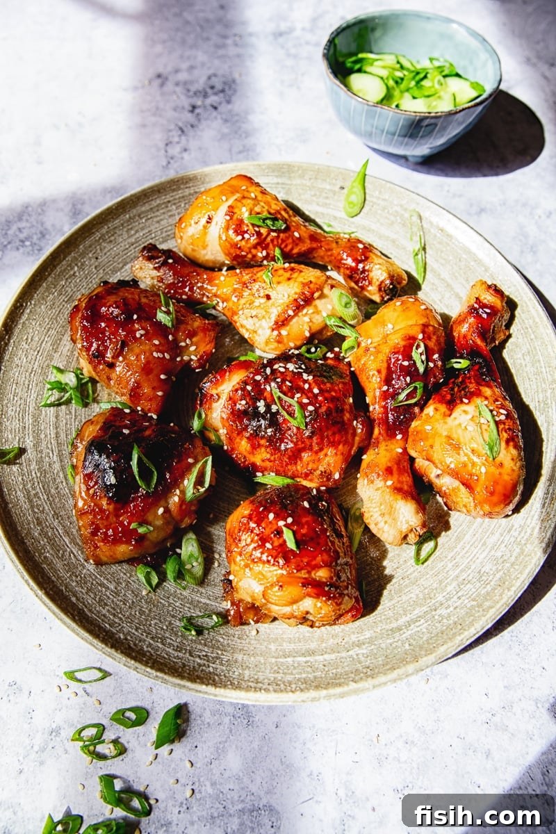 Cooked sticky Asian chicken arranged neatly on a sleek grey platter, ready for serving.