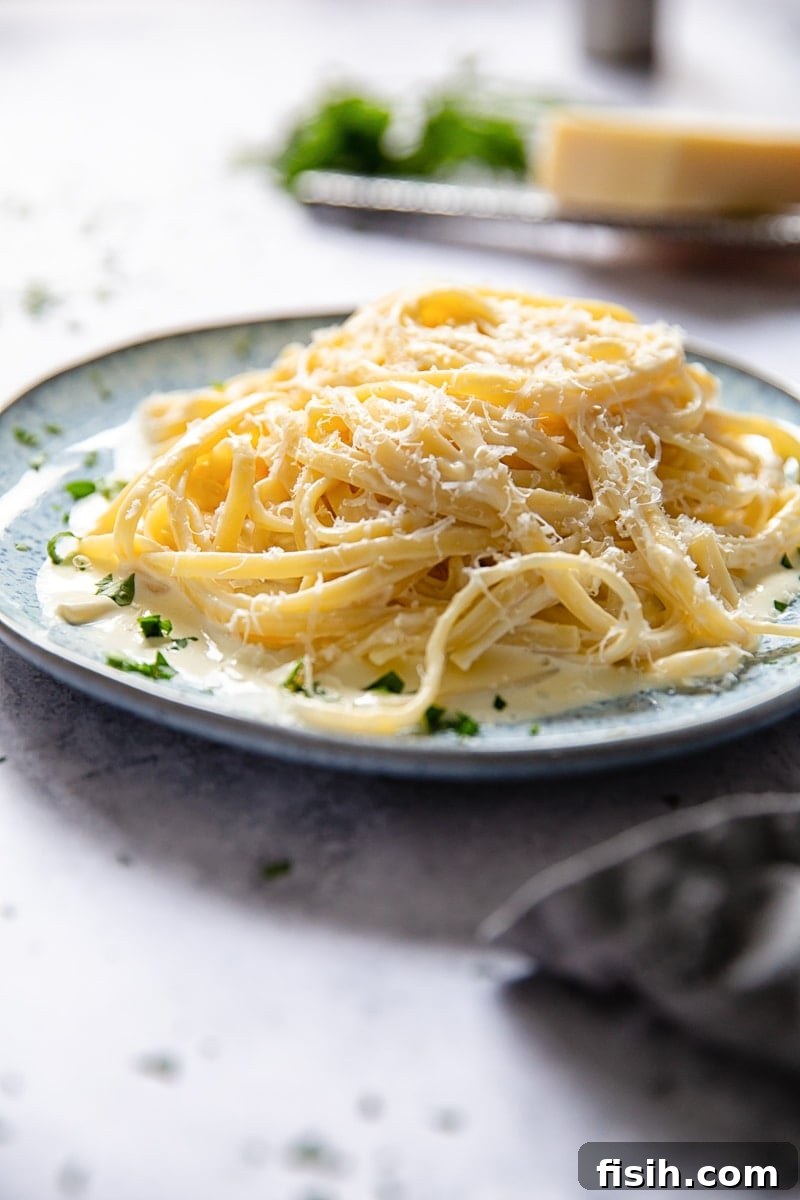 Side view of a plate of pasta in cream sauce