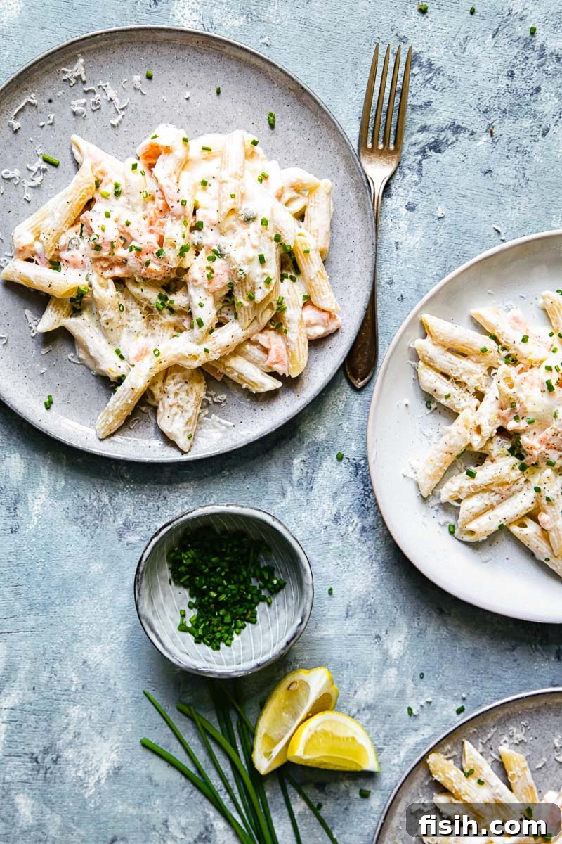 Top down view of a serving of pasta with smoked salmon, garnished with fresh herbs