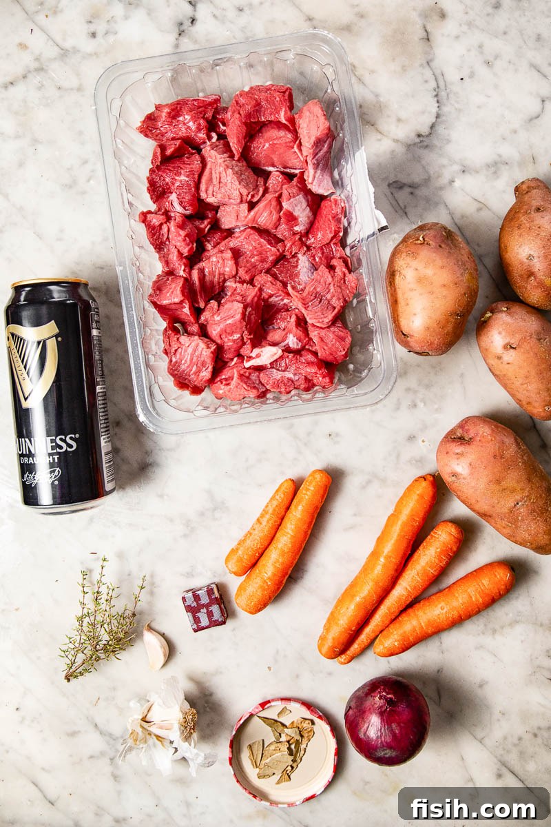 A flat lay photograph of all the raw ingredients neatly arranged for making Irish Beef Stew.