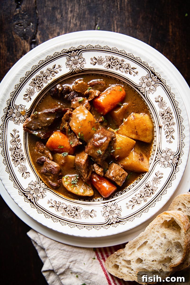 A beautifully presented bowl of Irish Beef Stew, featuring tender meat, vegetables, and a rich dark sauce.