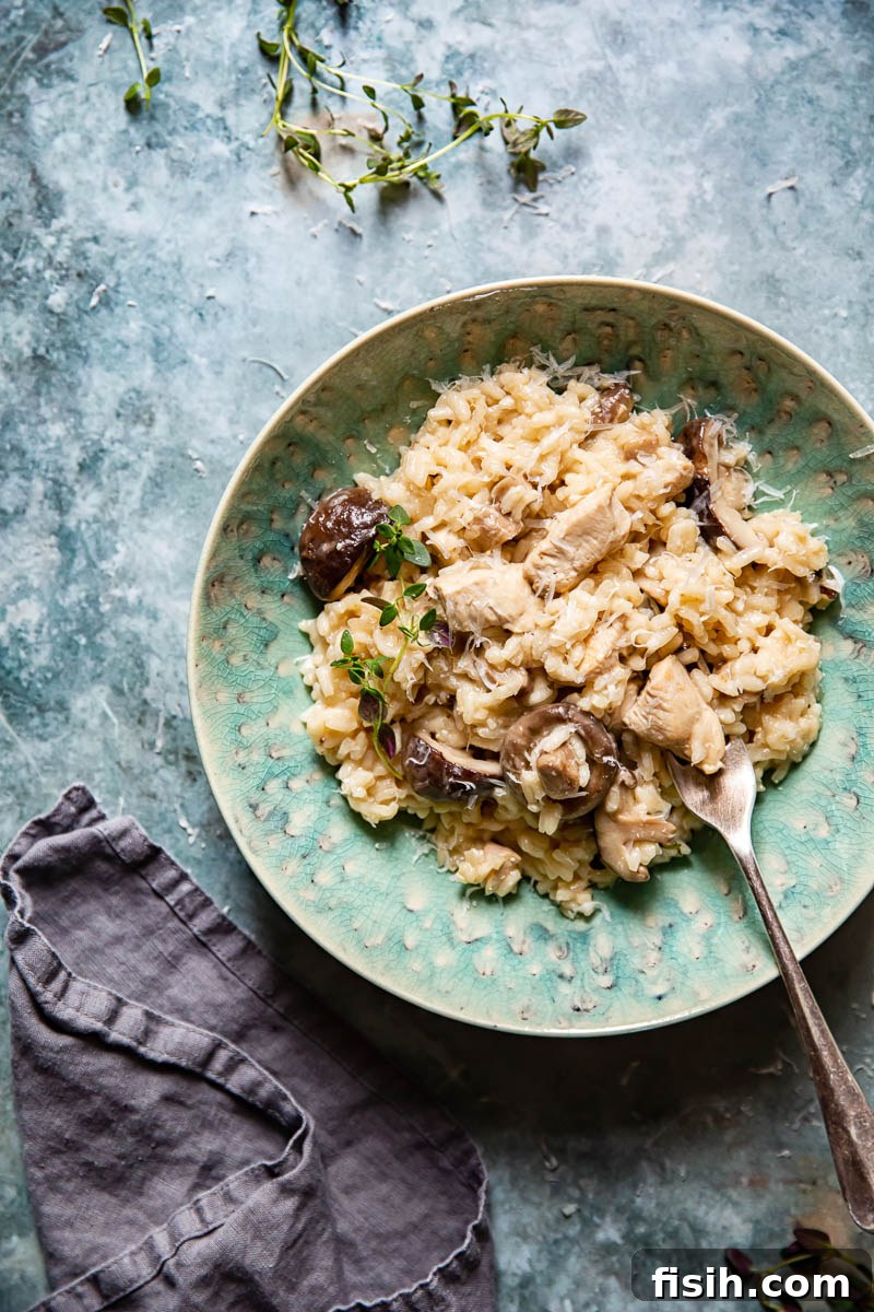 Creamy Chicken Risotto with Earthy Mushrooms and Aromatic Thyme 5 A top-down, close-up view of a rustic bowl filled with creamy Chicken Risotto with Mushrooms and Thyme, garnished with fresh herbs and black pepper, ready for a comforting meal.