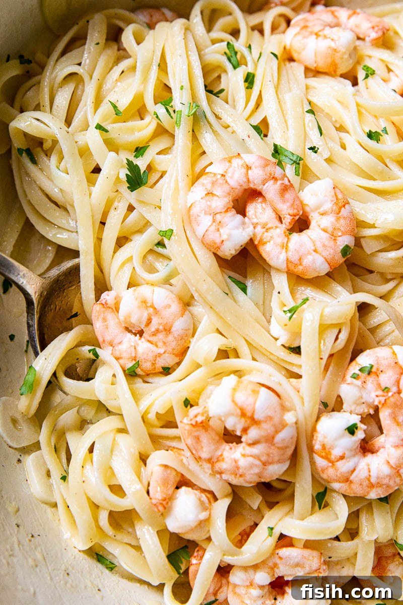 Close-up of Shrimp Scampi Linguine, with plump, perfectly cooked shrimp prominently arranged on top of the pasta, garnished with fresh herbs.