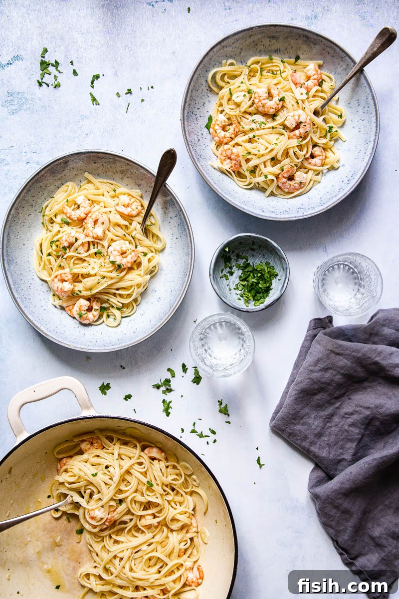 Top-down view of Shrimp Scampi Linguine served in individual bowls and also a larger cast iron pan, highlighting the generous portions and vibrant presentation.