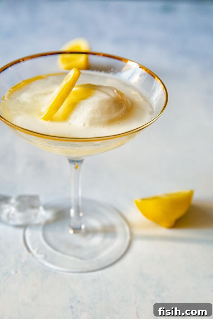Sgroppino cocktail, an Italian lemon Prosecco float, served in an elegant glass, garnished with a fresh lemon slice.