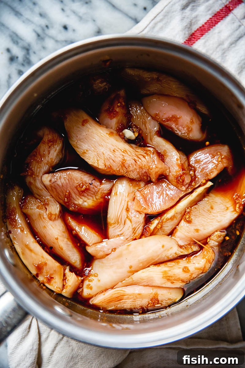 Chicken breasts gently poaching in soy sauce liquid