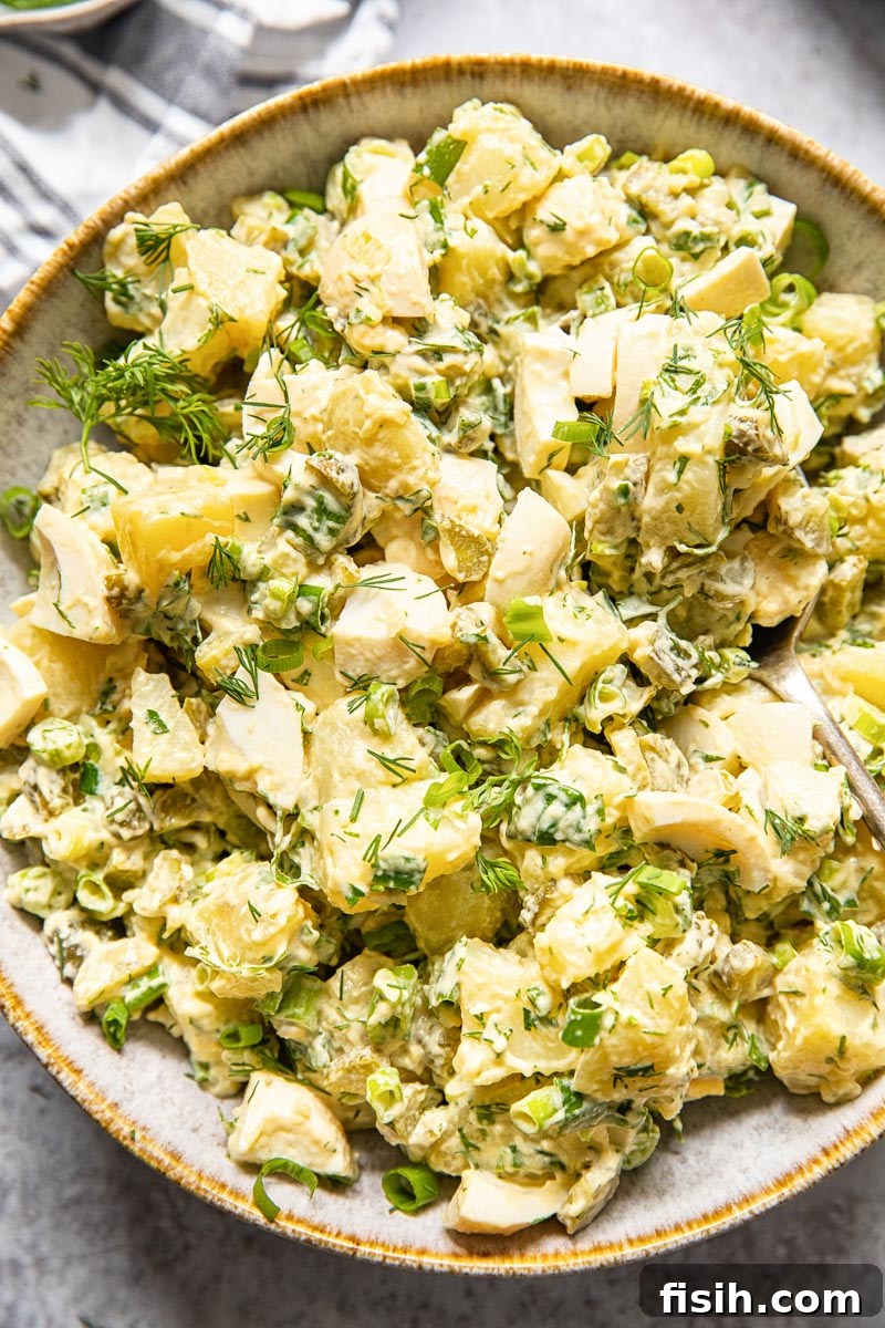 Creamy Fresh Dill Potato Salad 2 top down view of potato salad with dill and green onions, garnished with fresh herbs