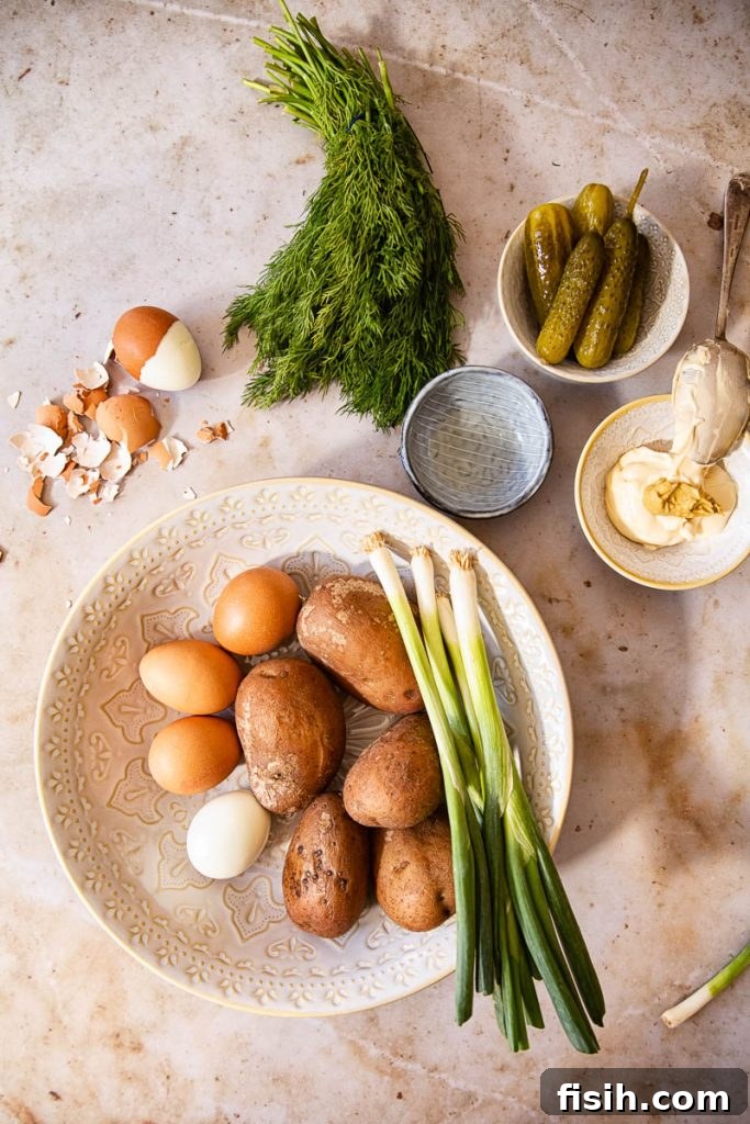 Creamy Fresh Dill Potato Salad 5 various ingredients for classic potato salad laid out on a table from overhead perspective