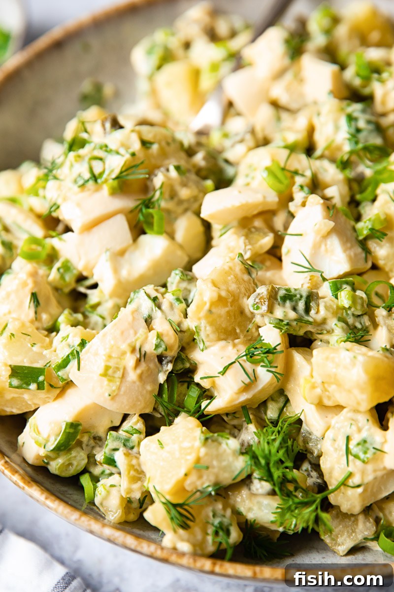 Creamy Fresh Dill Potato Salad 6 side view of a bowl of dill potato salad with fresh herbs