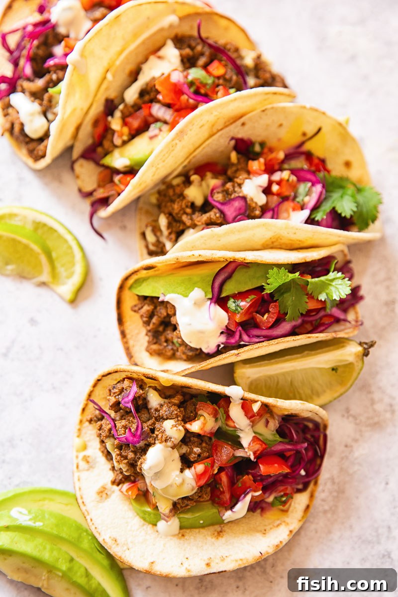 Beautifully arranged Beef Tacos, lavishly topped with fresh pico de gallo and a crunchy slaw, ready for serving.