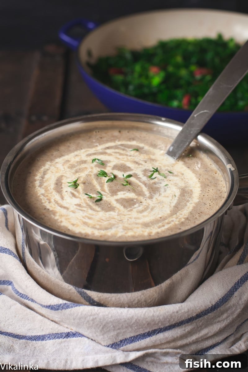 A rich, creamy mushroom soup simmering gently in a rustic pot, with a delicate swirl of fresh cream drizzled on top, ready to be served.