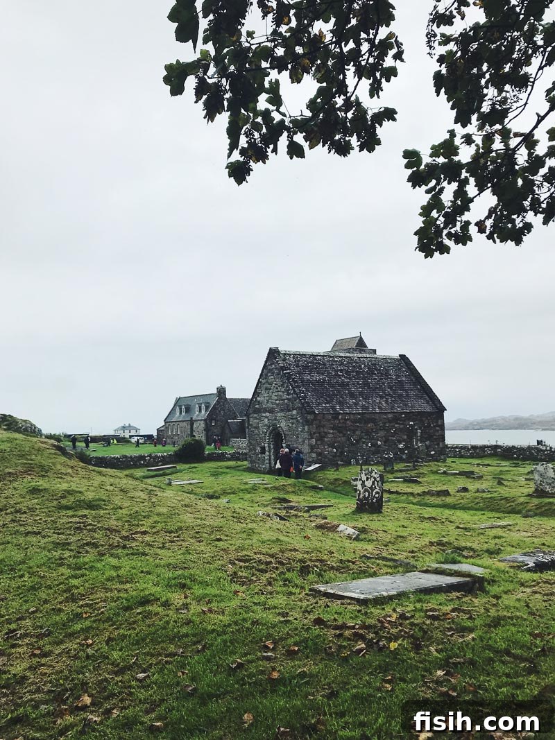 Unveiling Mull's Island Magic 4 Historical Iona Abbey under a dramatic sky, surrounded by green fields and ancient stones.