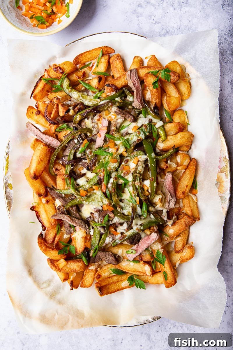 Smothered Philly Cheesesteak Fries 2 Crispy golden fries laden with thinly sliced steak, vibrant green peppers, and gooey melted cheese, ready to be devoured.