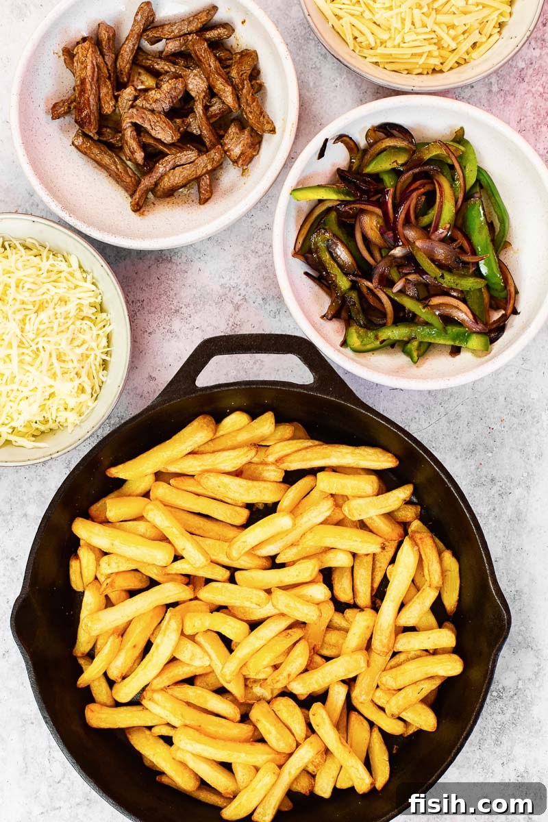Smothered Philly Cheesesteak Fries 4 All the fresh ingredients laid out for making Philly Cheesesteak Loaded Fries, including steak, peppers, onions, and two types of cheese.