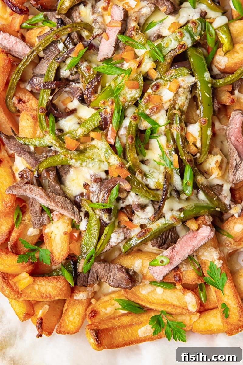 Smothered Philly Cheesesteak Fries 5 Robust chunky chips topped generously with strips of seasoned steak, sautéed green peppers, sweet onions, and a luscious blanket of melted cheese.