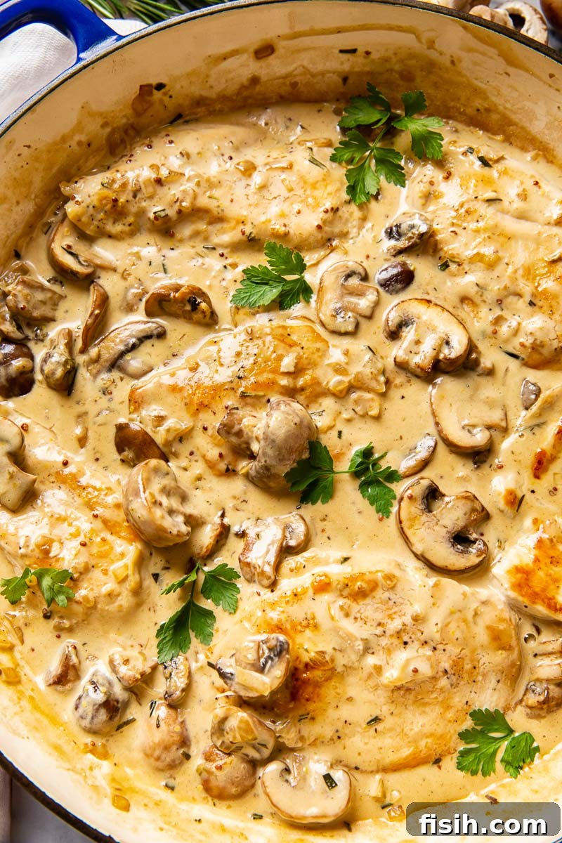 Golden seared chicken breasts generously coated in a creamy garlic mushroom sauce, garnished with fresh parsley.