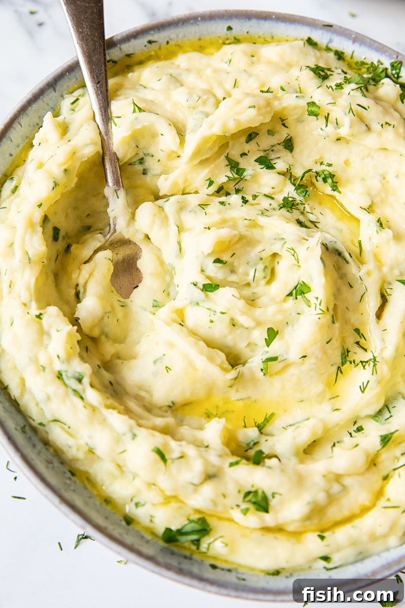 Savory Garlic Herb Mash 4 Close-up of potato mash with fresh herbs and a pat of butter melting on top.