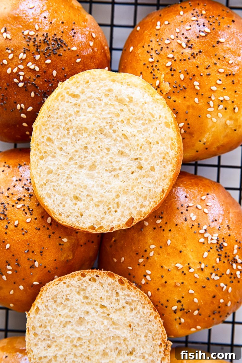 A homemade hamburger bun cut in half, revealing its incredibly soft, airy, and brioche-like interior crumb.