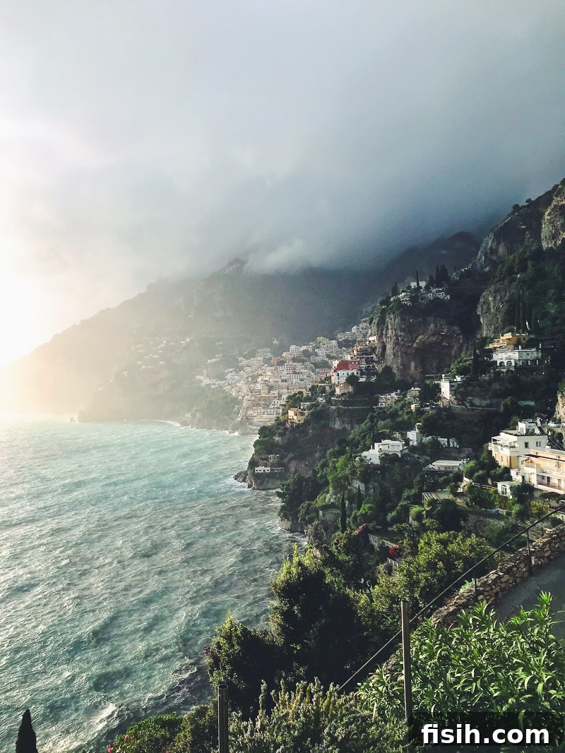 A panoramic view of the dramatic Amalfi Coastline, showcasing colorful cliffside towns and the sparkling Mediterranean Sea under a bright sky.