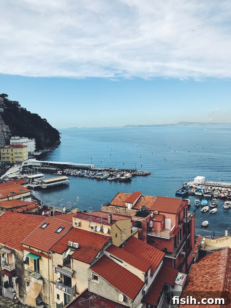 The picturesque coastal town of Sorrento, Italy, with colorful buildings cascading down to the sea, vibrant greenery, and a bustling port, under a vibrant sunset.