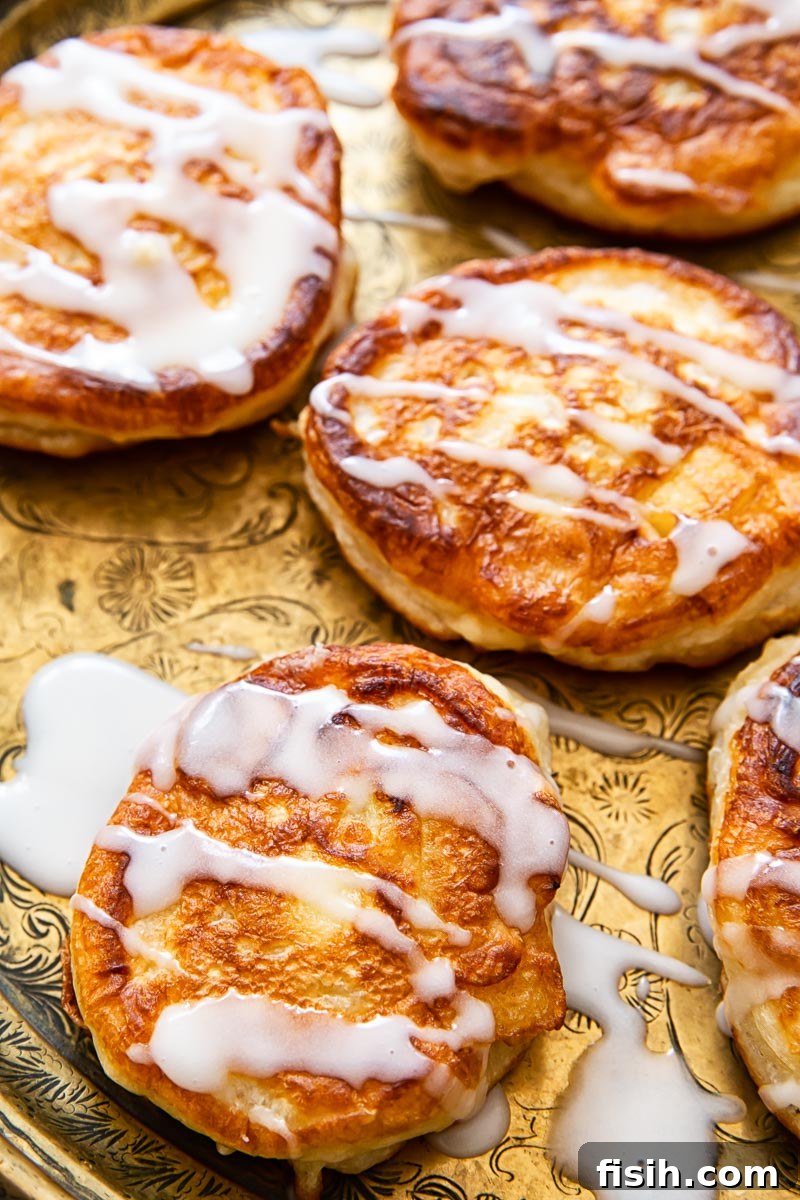 apple fritters drizzled with sugar glaze close up