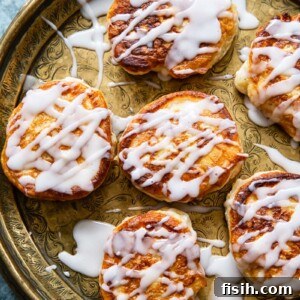overhead view of apple fritters drizzled with sugar glaze on platter