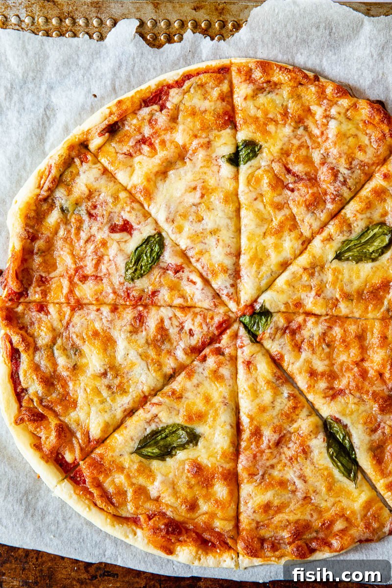 Crispy Puff Margherita 2 Top down view of puff pastry pizza margherita on a baking tray, showcasing its golden crust and melted mozzarella