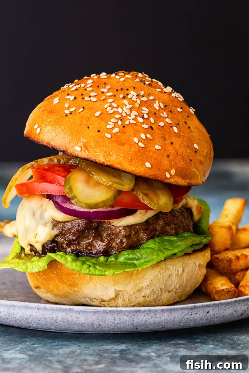 a cheeseburger with onion, tomatoes and pickles