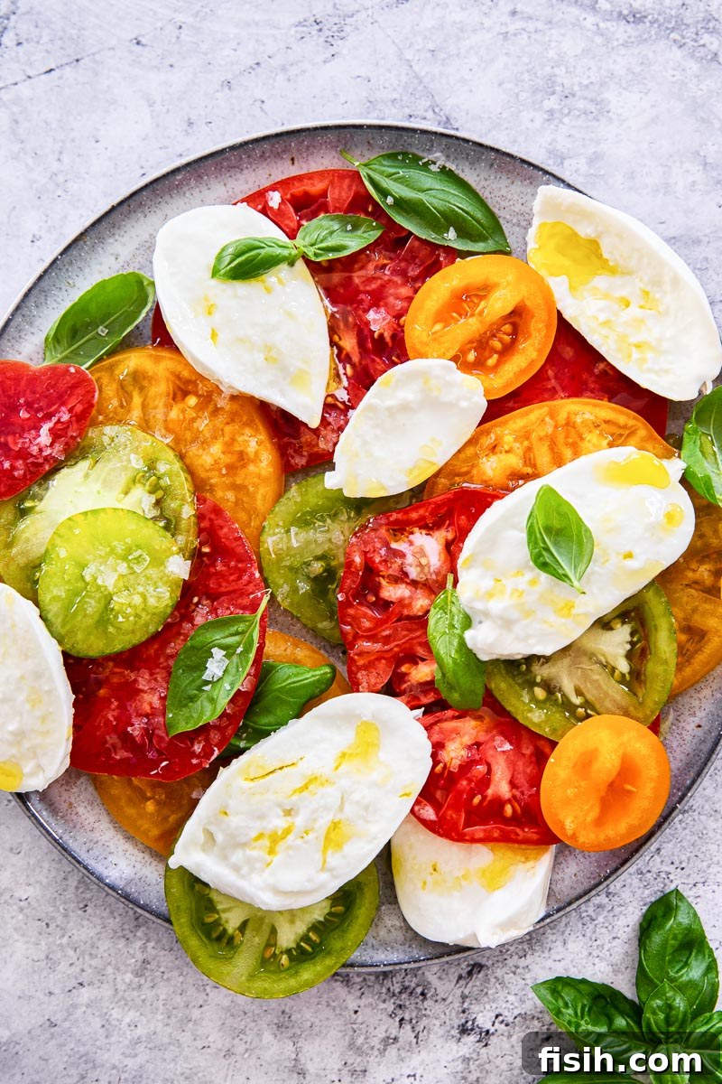Caprese Dream: Juicy Tomatoes, Aromatic Basil, Creamy Mozzarella 5 classic Insalata Caprese served elegantly on a grey plate