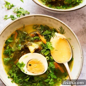 soup topped with greens and a hard boiled egg