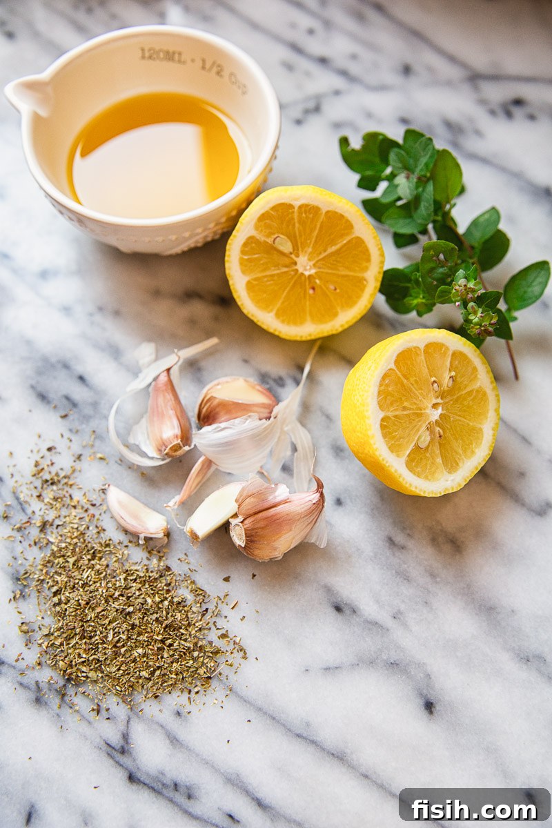 Ingredients for Greek marinade: fresh lemon halves, olive oil, minced garlic, and dried oregano.