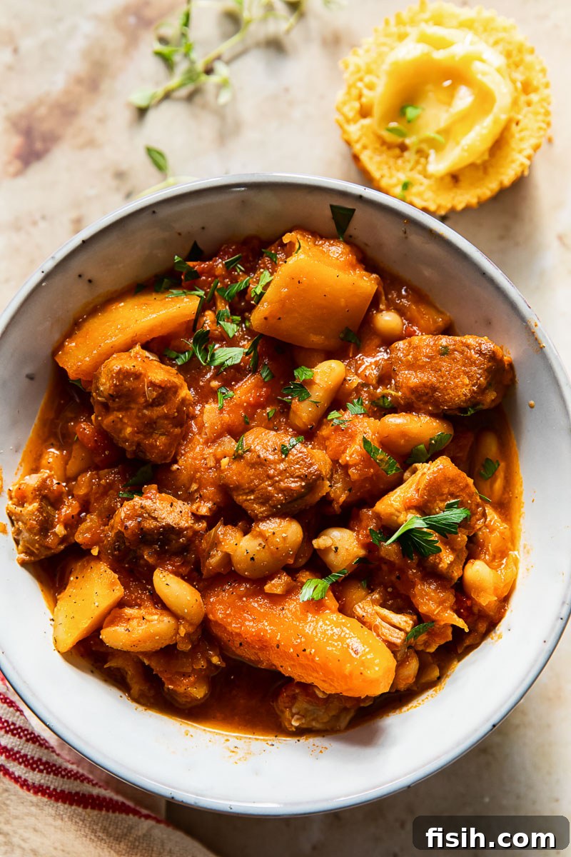 A delectable bowl of slow cooker campfire stew, featuring tender pork shoulder, carrots, and butternut squash, ready to be enjoyed.
