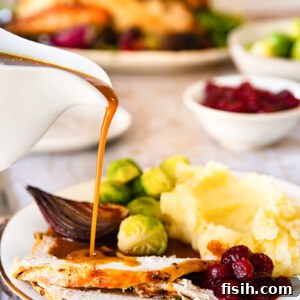 Gravy being poured on sliced of turkey
