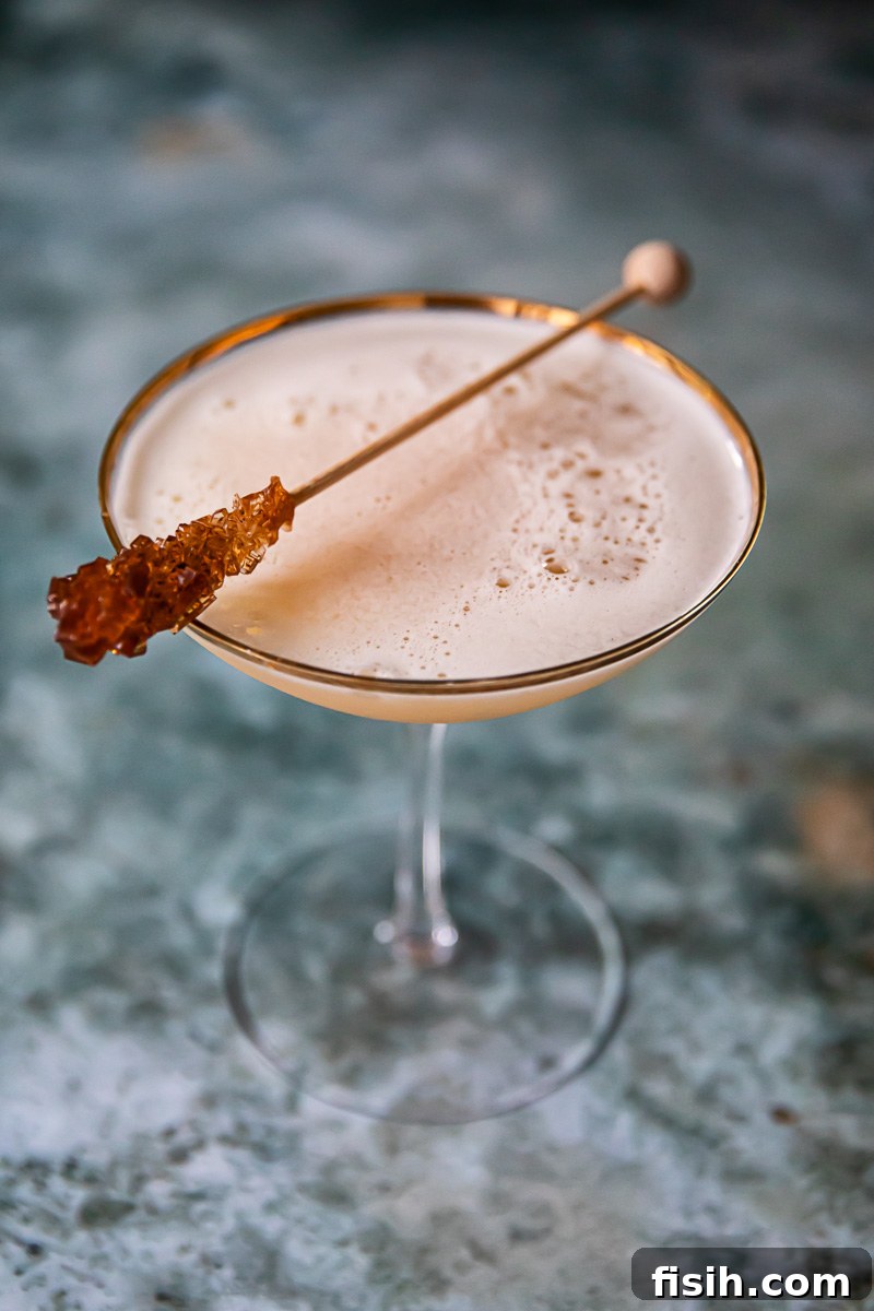 top down view of maple cider whiskey sour on dark blue background