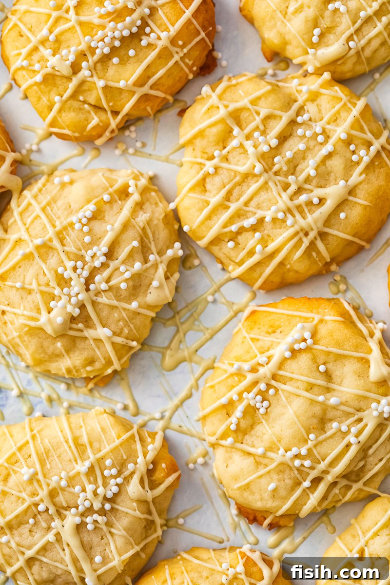 Soft and light lemon ricotta cookies with a delicate white chocolate drizzle and festive white sprinkles, perfect for holiday gatherings.
