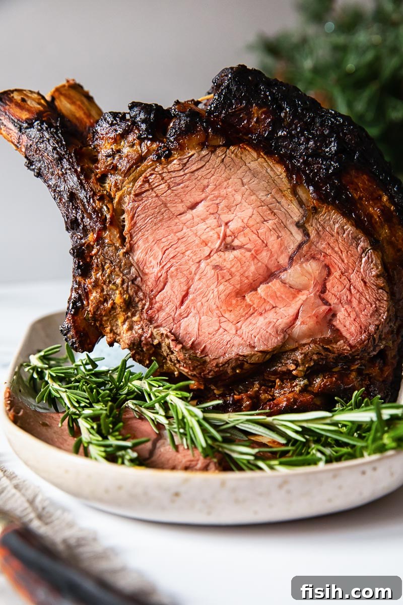 Zesty Honey Mustard Crusted Prime Rib Roast 5 prime rib on a platter with fresh rosemary in the foreground