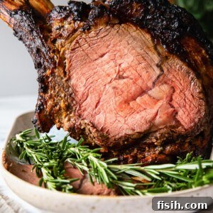 Zesty Honey Mustard Crusted Prime Rib Roast 6 prime rib on a platter with fresh rosemary in the foreground