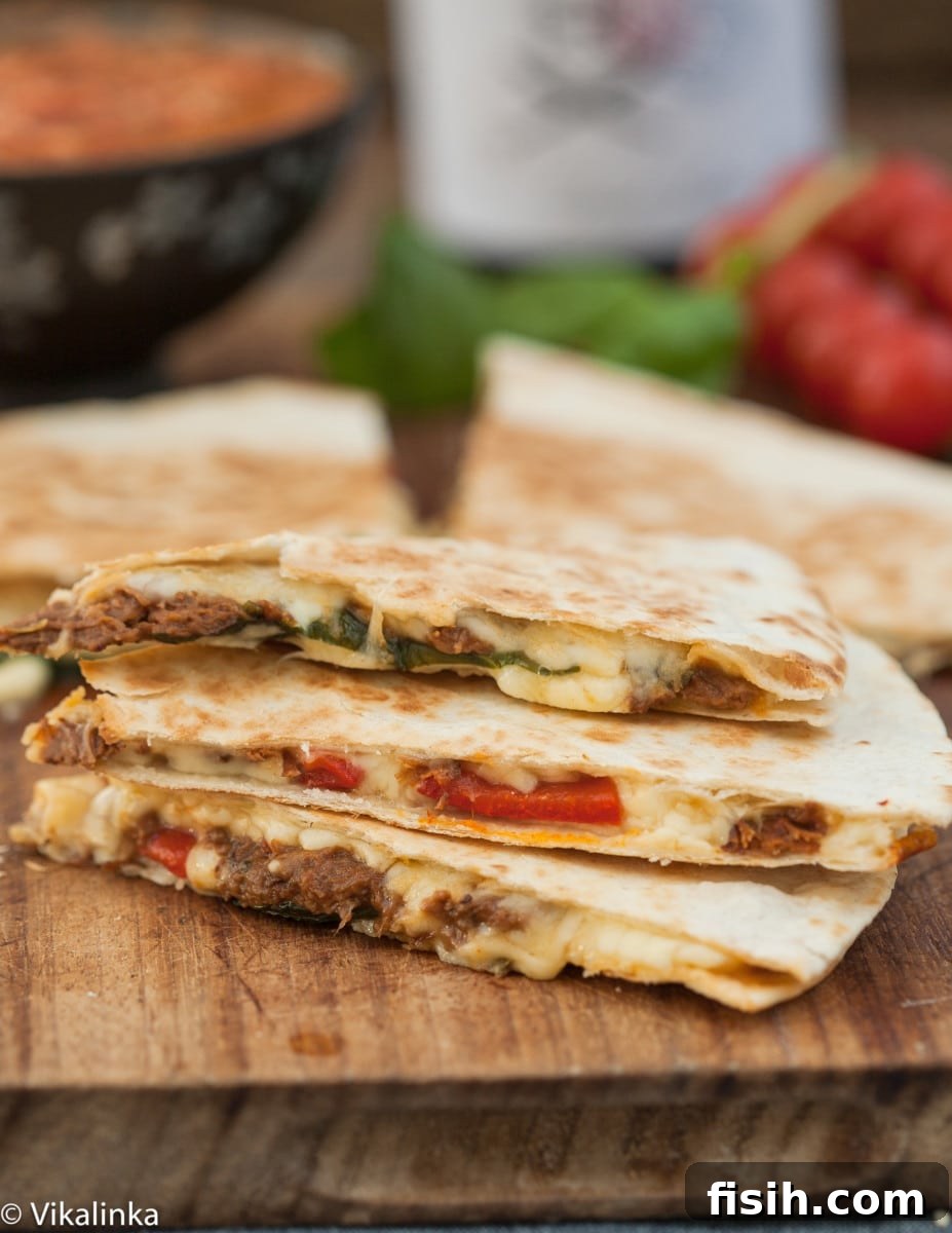 Close-up of perfectly cooked Italian Beef Quesadilla wedges, stacked and ready to be served.