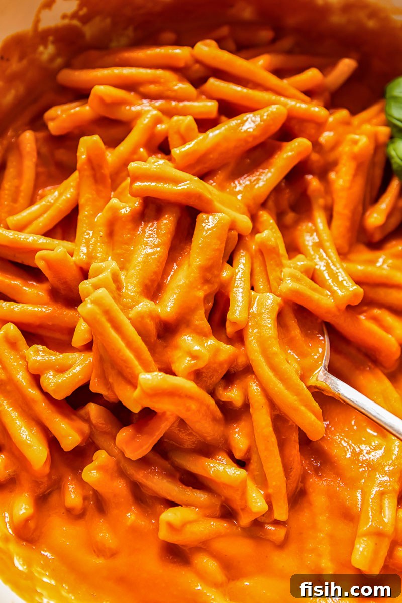Velvety Vodka Pasta Sauce 2 A bowl of pasta generously coated in silky smooth vodka sauce, garnished with fresh basil.