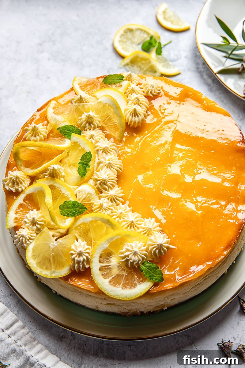 lemon cheesecake decorated with lemon slices and whipped cream rosettes